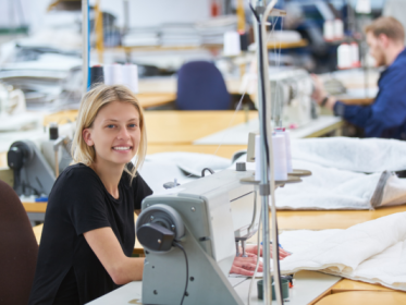 Blonde vrouw achter naaimachine