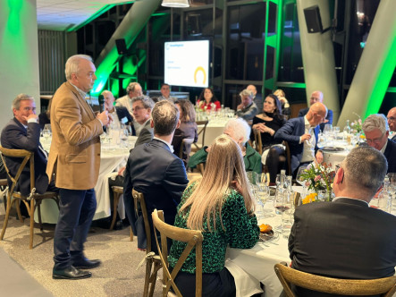 Dinersetting met man in bruin colbert die speecht