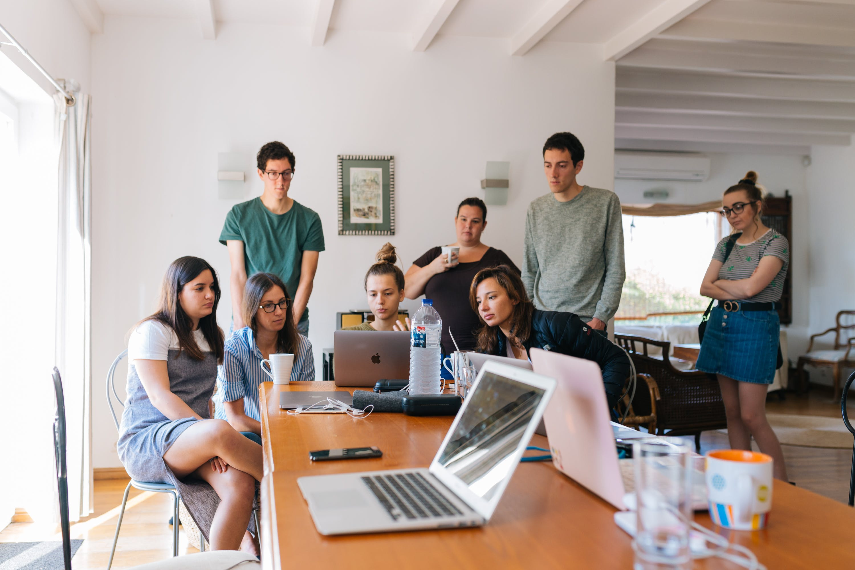 Groep young professionals kijken naar een laptopscherm achter een bureau