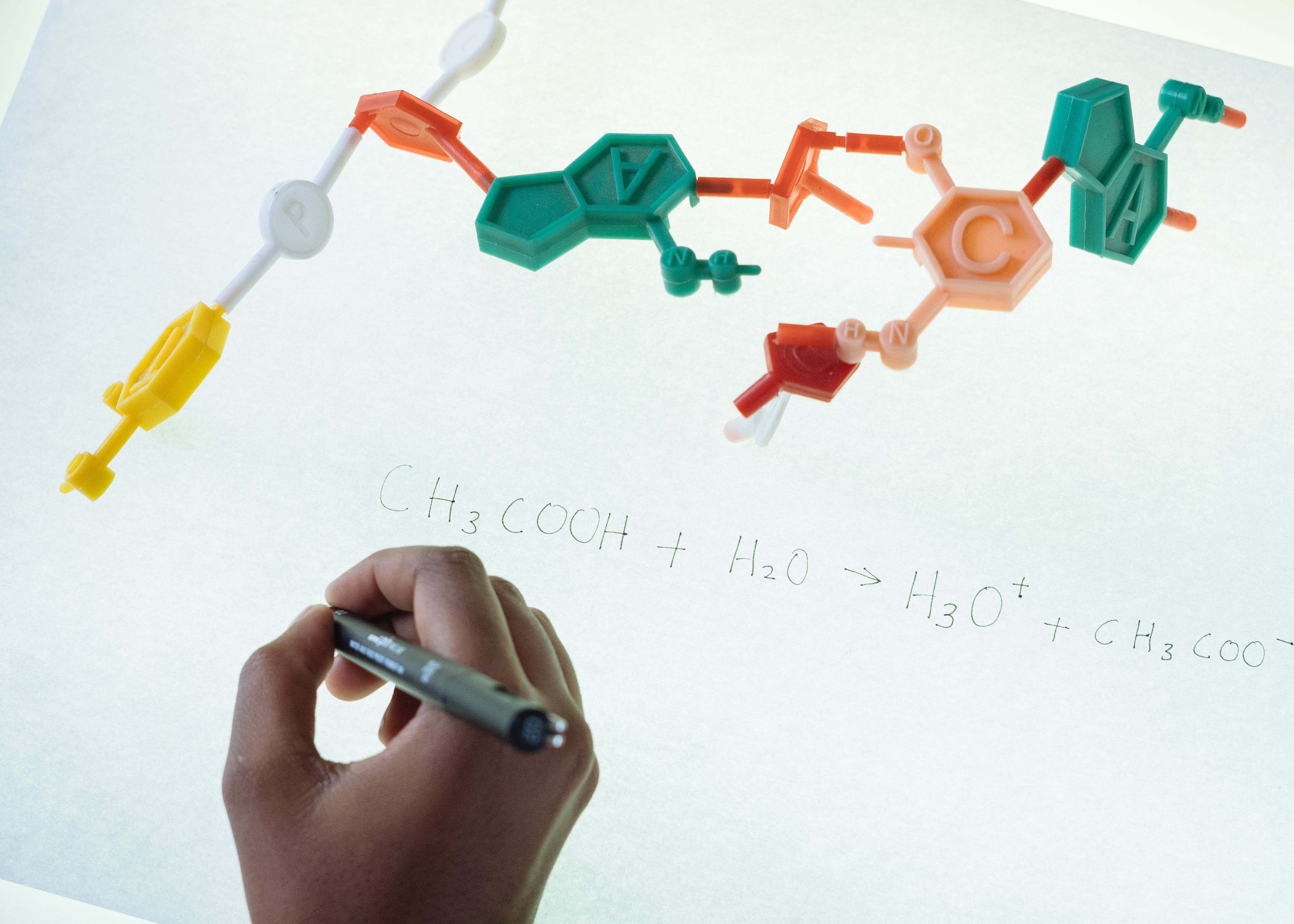moleculen en een hand die formule opschrijft