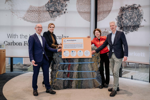 Drie personen poseren rondom samenwerkingsverklaringsbord